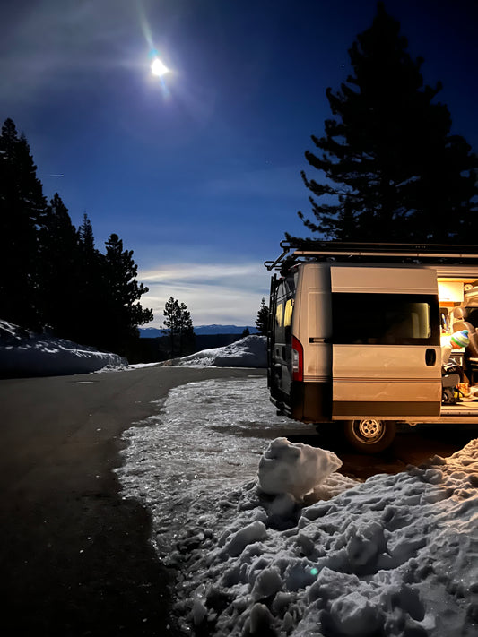 Van with an open door at night in a snow covered parking lot